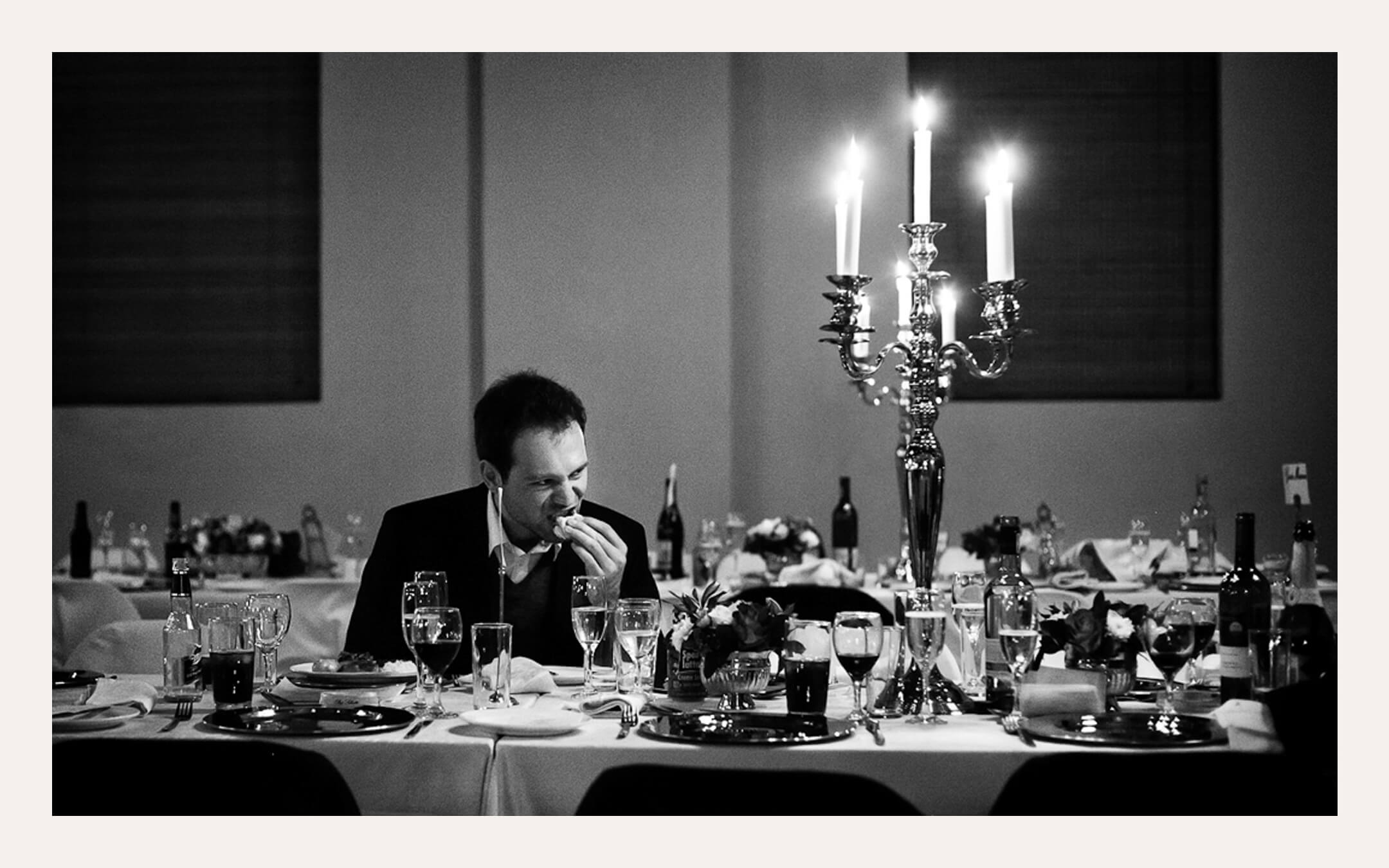 Groom at a candlelit dinner table after the reception. Ben Viljoen Photography