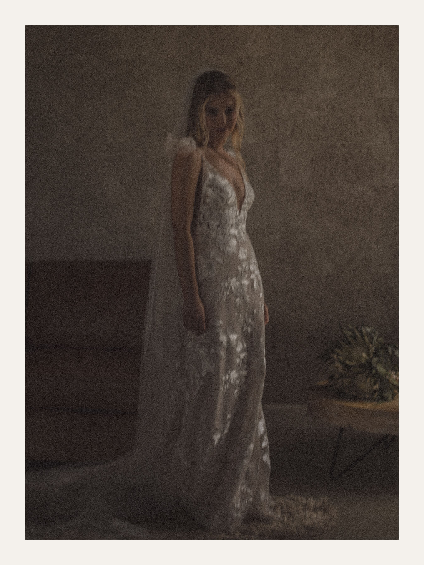 Bride standing quietly against a bare wall in soft window light. Ben Viljoen Photography