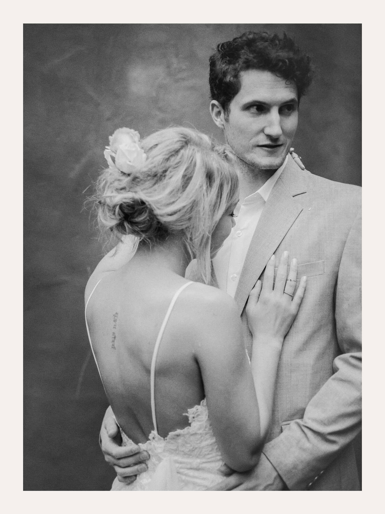 Groom holding a bride from behind, her back to the camera. Ben Viljoen Photography