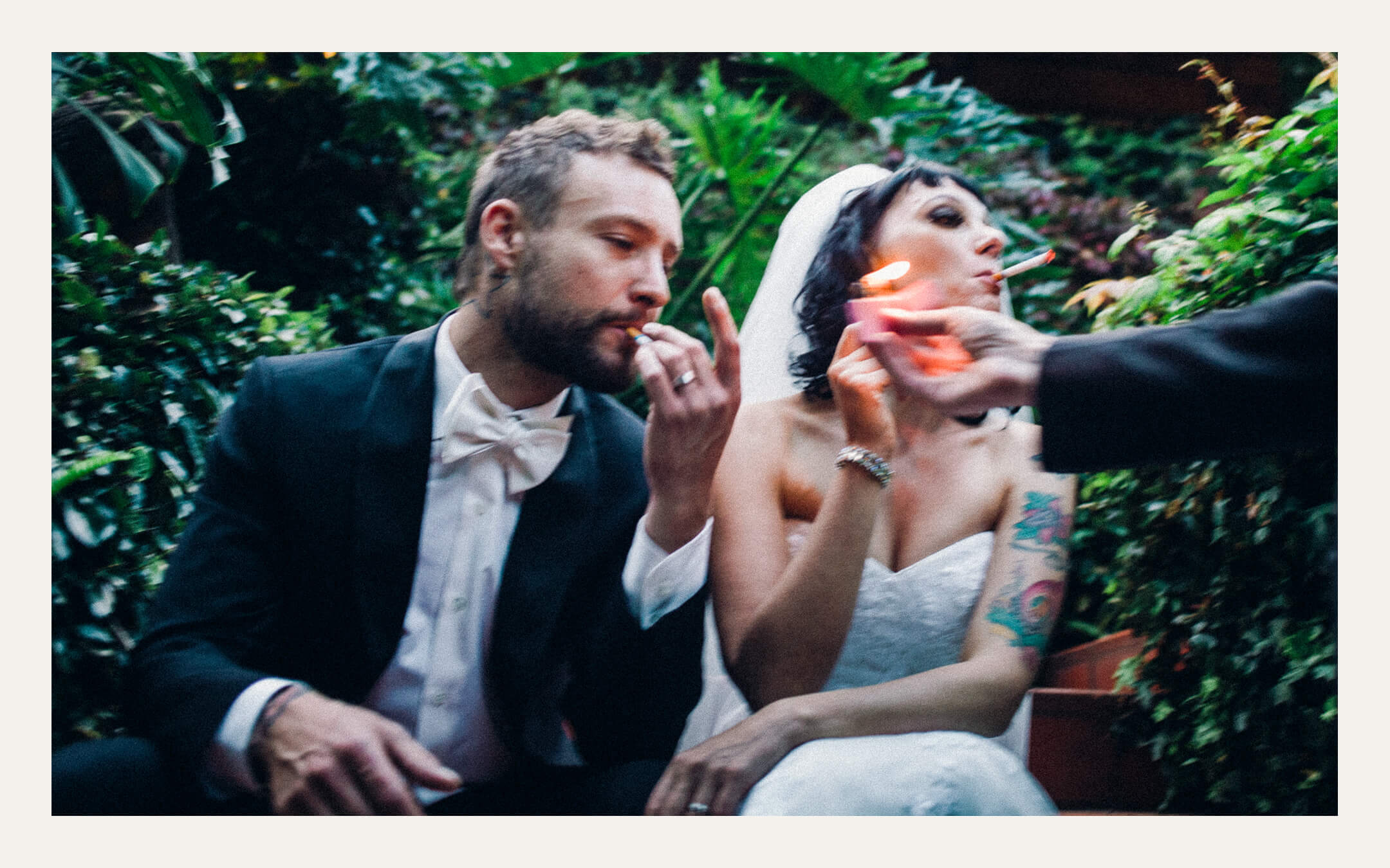 Bride and groom sharing a cigarette in a garden after the reception. Ben Viljoen Photography