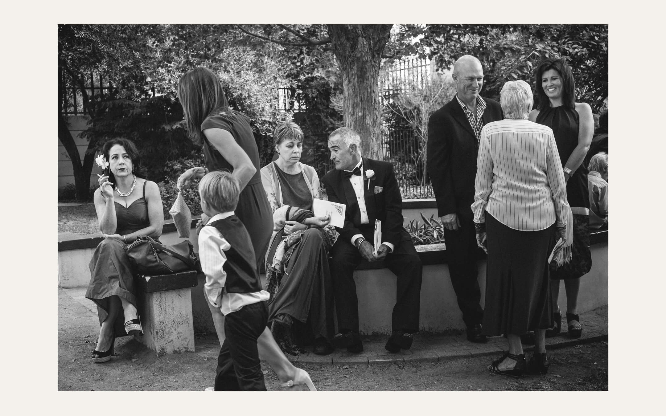 Guests standing and sitting together outside after the ceremony. Ben Viljoen Photography
