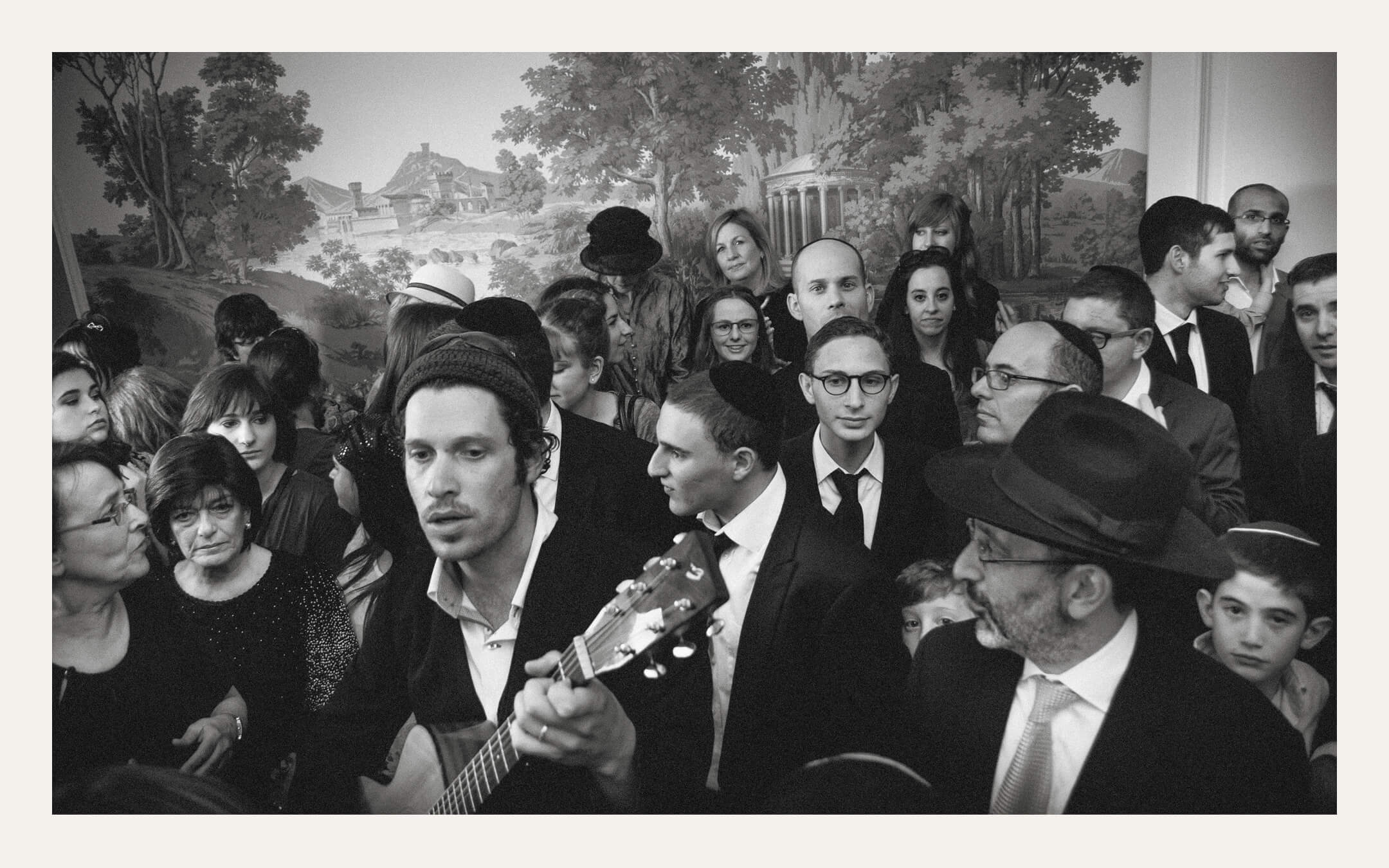 Guests crowded around a guitarist singing at the reception. Ben Viljoen Photography